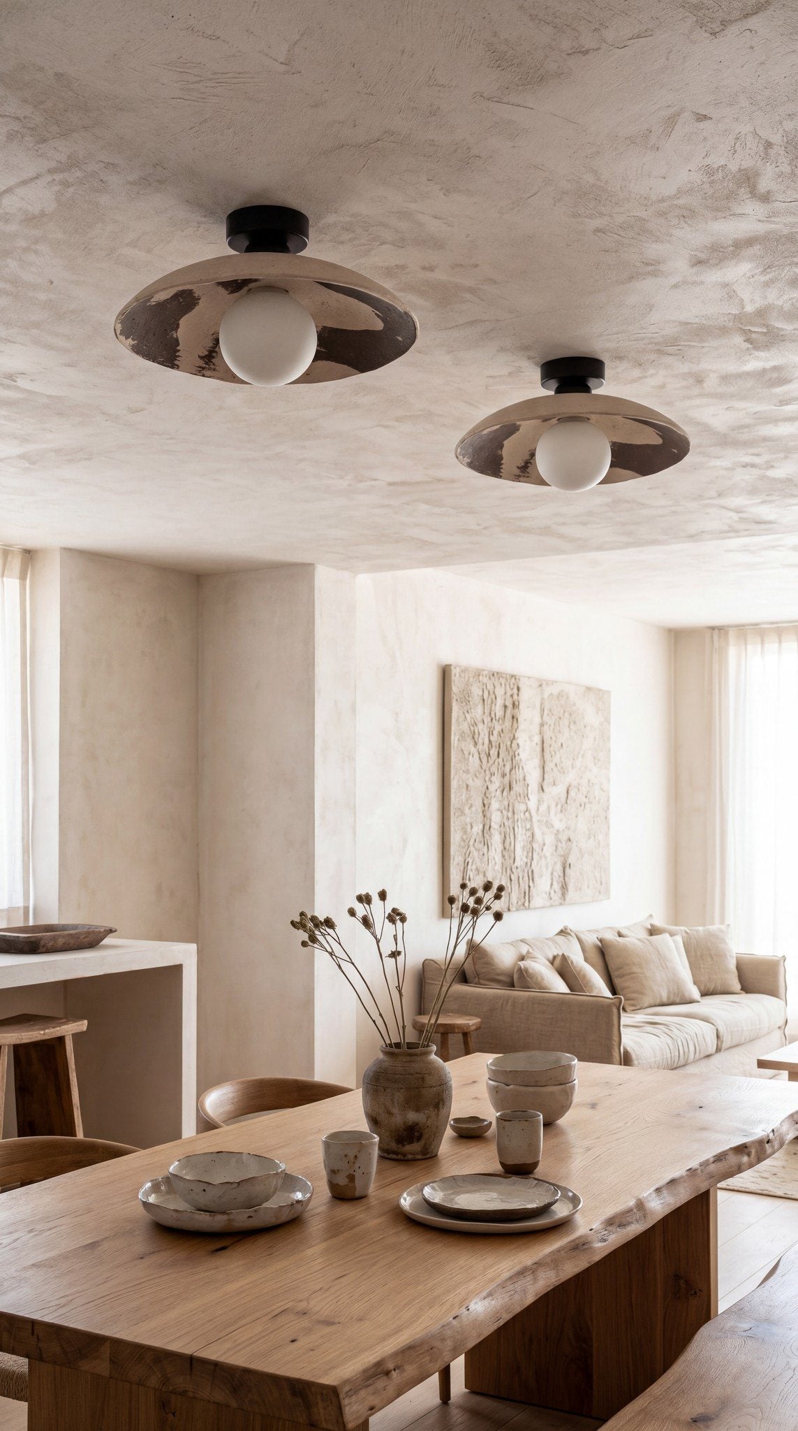 Two Nara ceramic ceiling lights above a live-edge oak dining table in a warm minimalist home