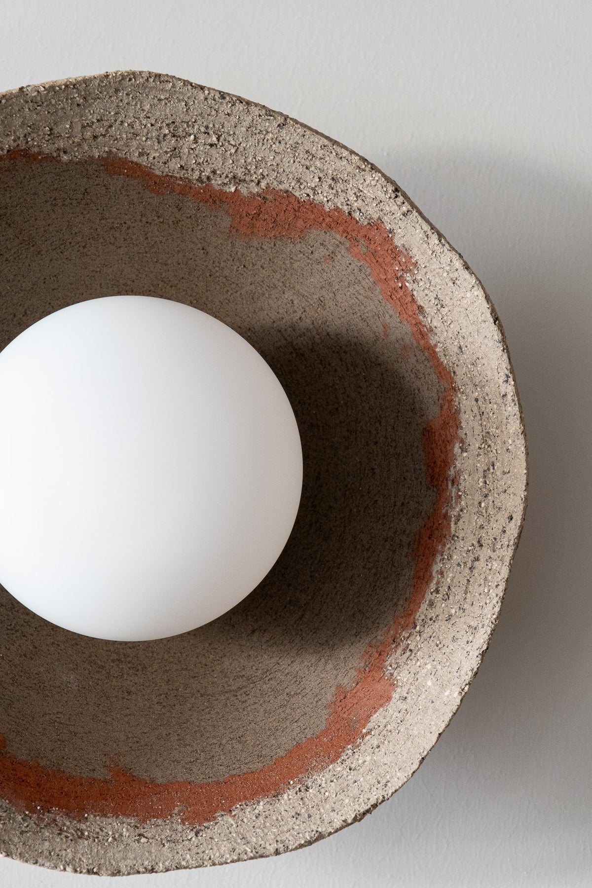 Bottom view of the Kaya ceramic ceiling light with opal globe bulb and handmade clay shade